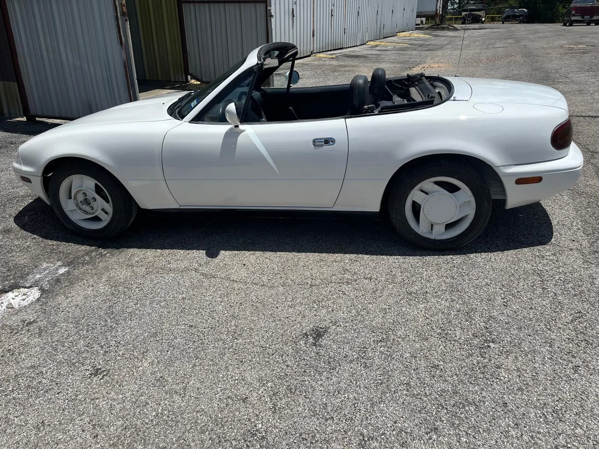 Restored white Miata roadster, side view